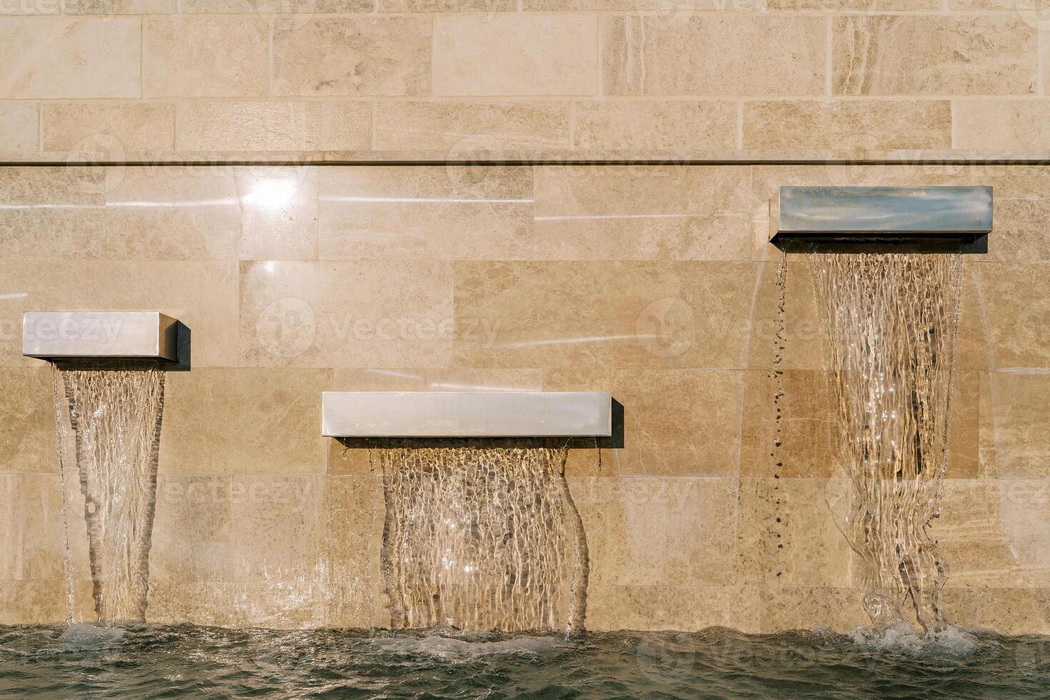 Modern rectangular fountains on a marble wall photo