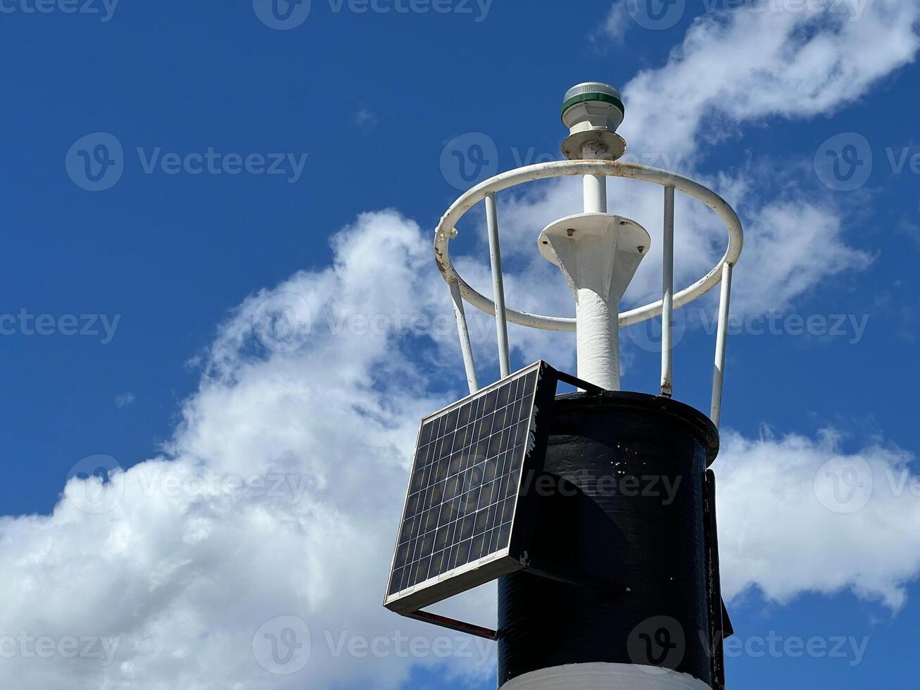 A Solar Powered Navigation Beacon Brightly Shining Against Blue Sky photo