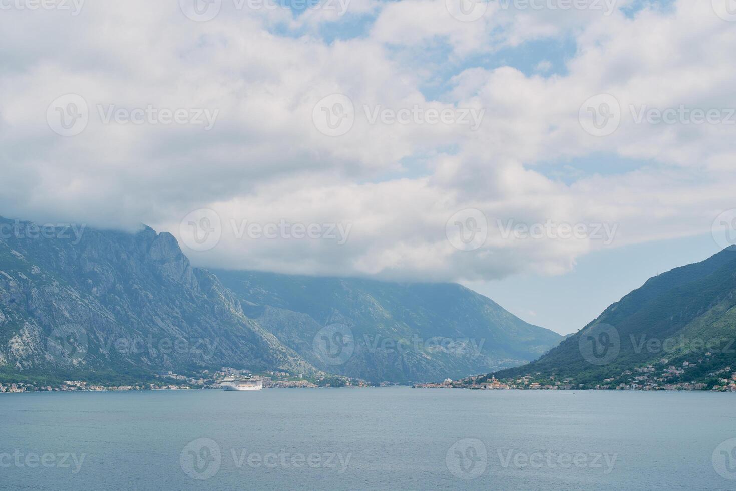 Large cruise ship sails in the Bay of Kotor along a mountain ridge in the fog. Montenegro photo