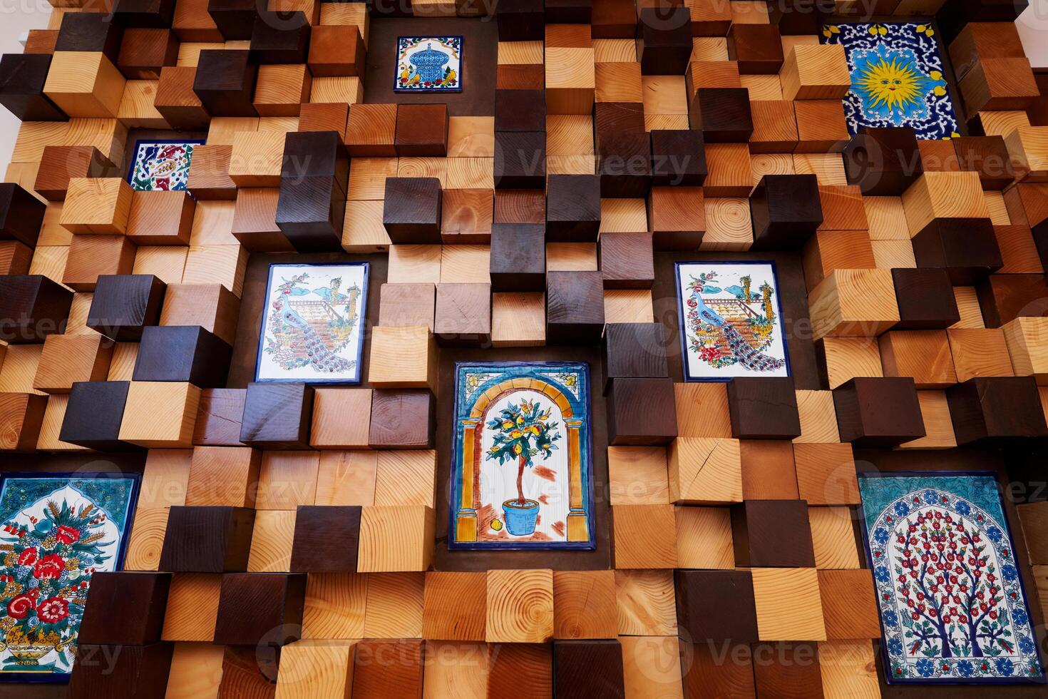 Wooden panel of light and dark cubes with inserts of colorful paintings photo