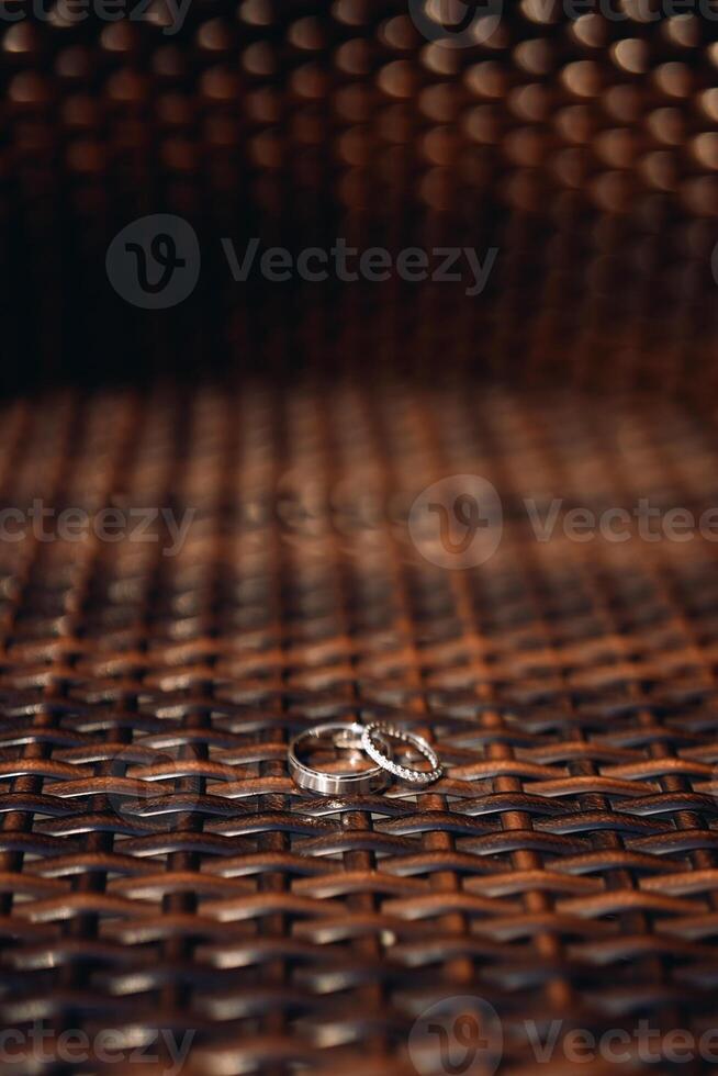 Wedding rings lie on a brown wicker chair photo