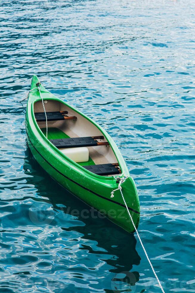 A Serene Green Canoe Gently Afloat on Clear and Calm Water photo