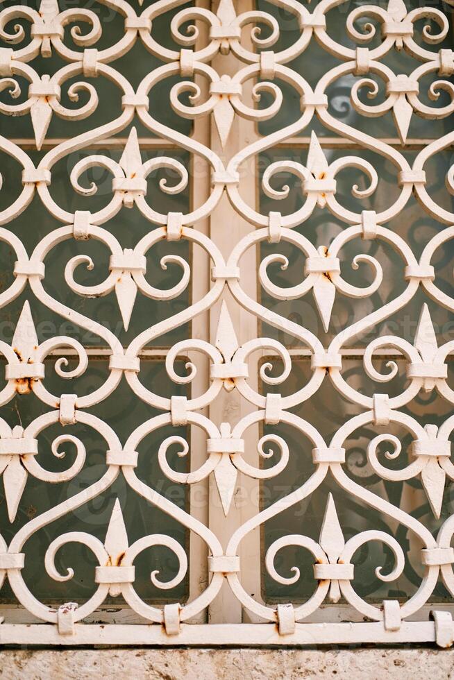 White metal grate on a wooden window with vintage patterns photo
