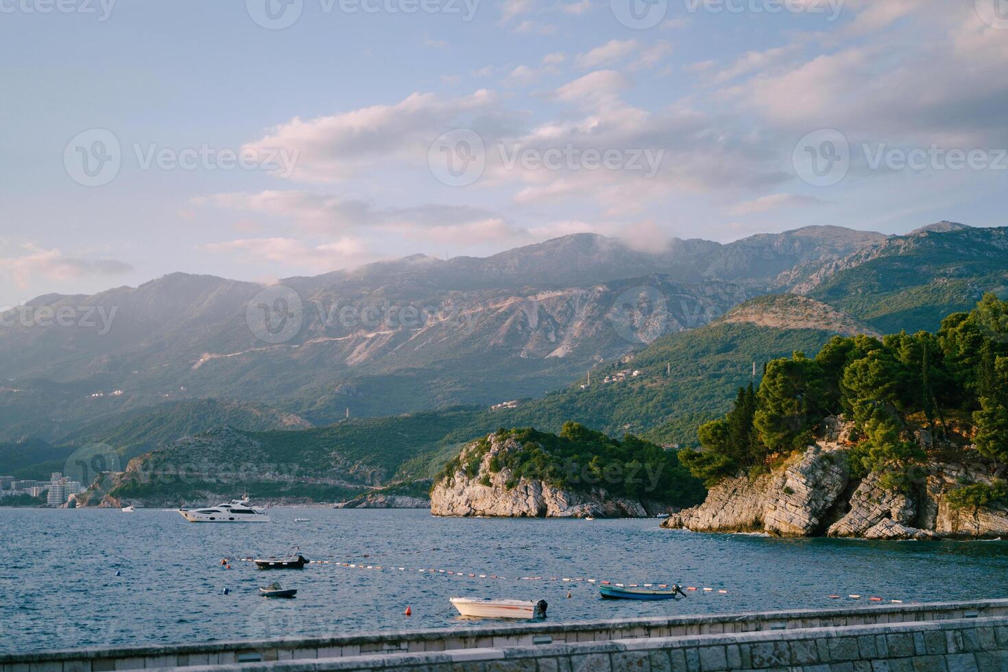 Yacht sails along the bay against the backdrop of a mountain range photo