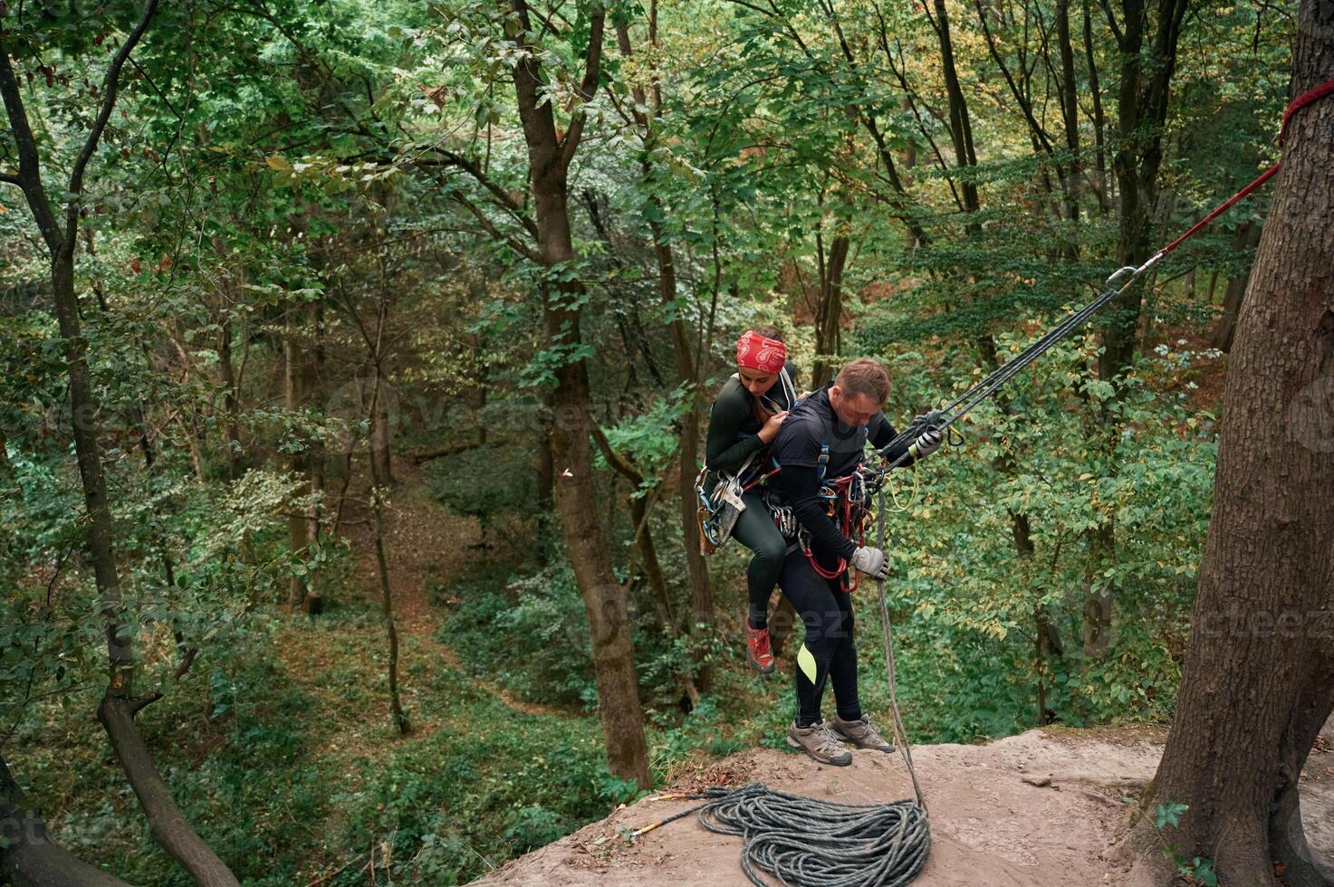 In the, forest. .Man and woman doing climbing with use of safety equipment photo