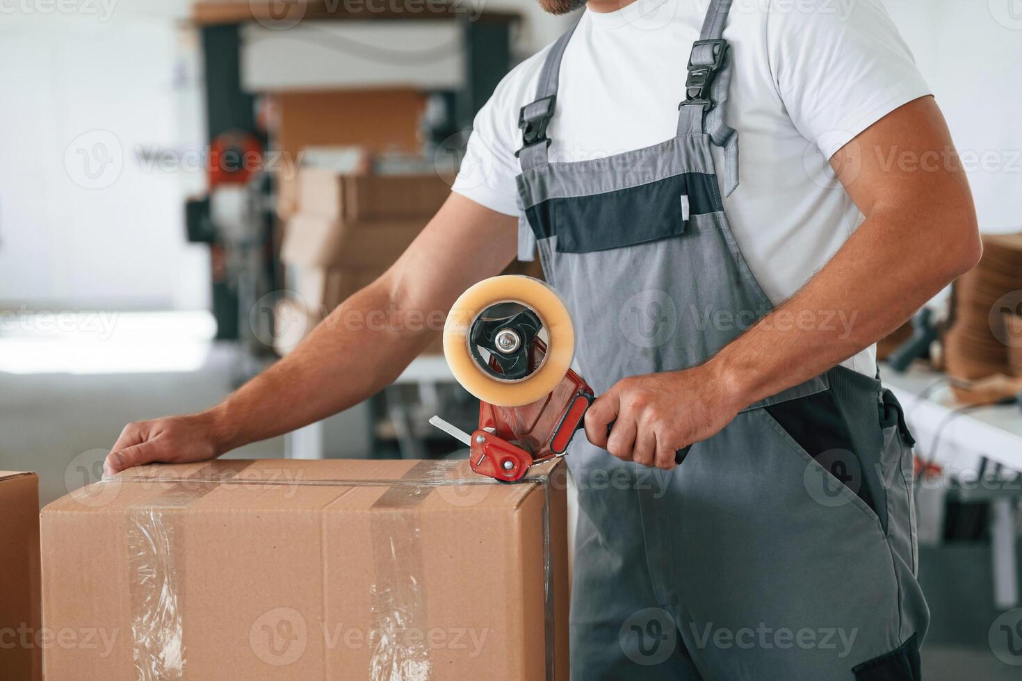 Packing, the product. Handsome man ,,is working at the factory of creating eco boxes photo