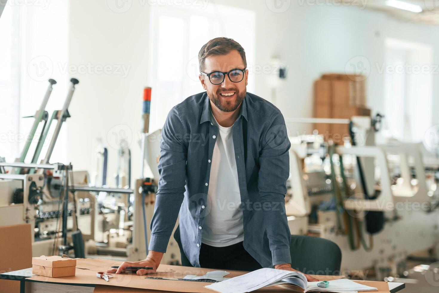 Positive facial ,,expression. Handsome ,man is working at the factory of creating eco boxes photo