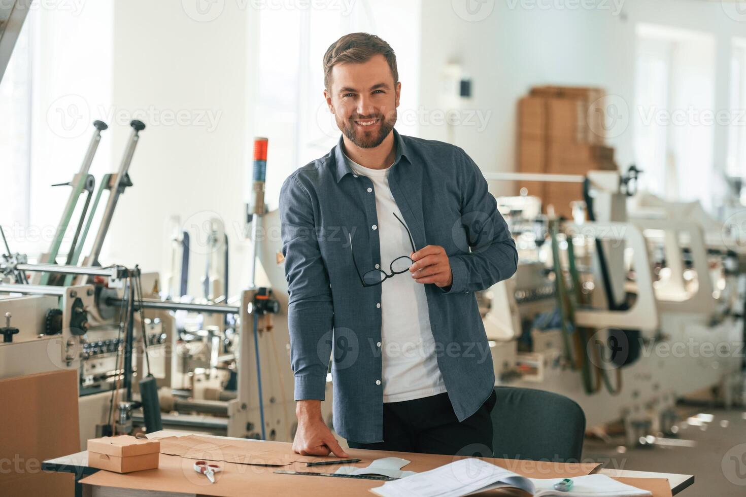 Positiv,e facial expression.. Handsome, man is working at the factory of creating eco boxes photo