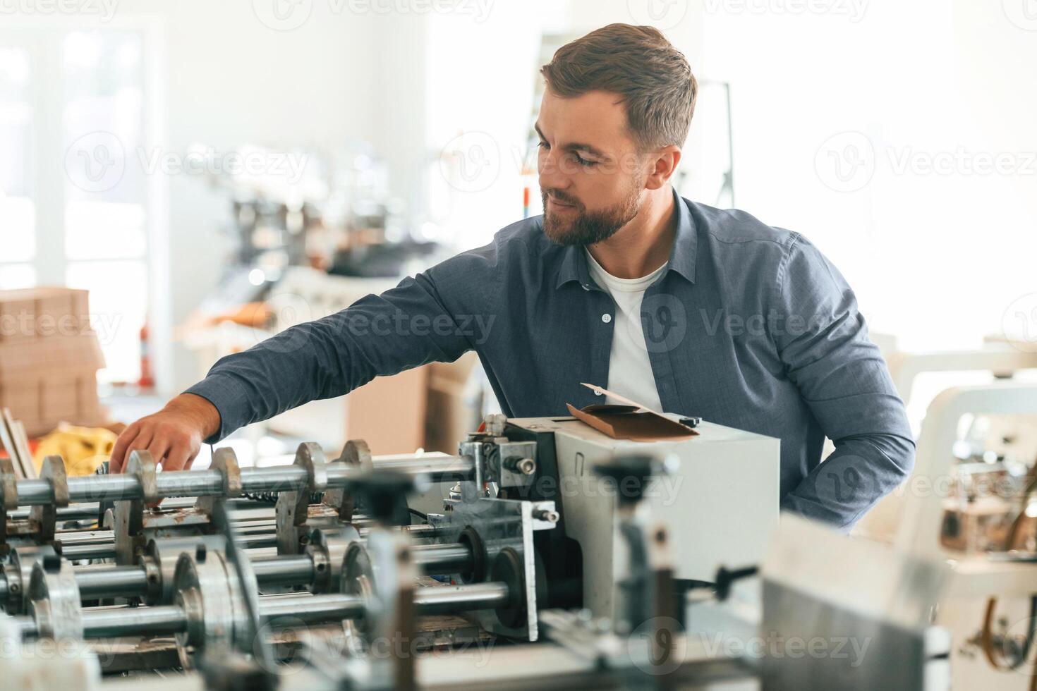 Front view. Handsome man ,is, working at the factory of creating eco boxes photo