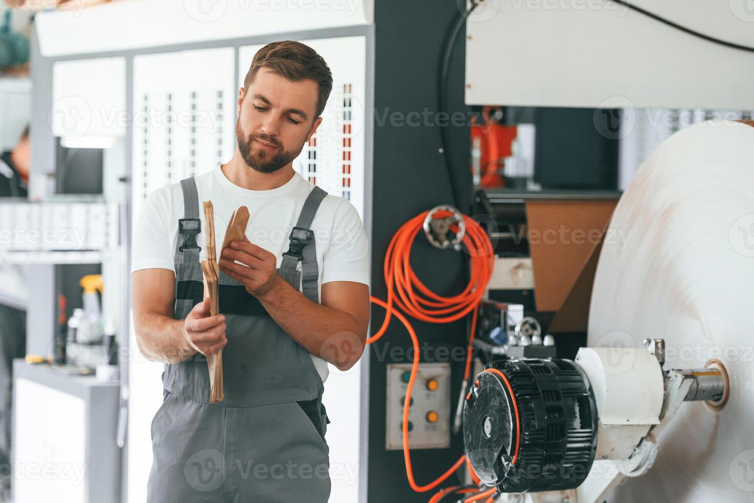 Smart engineer. Handsome, man, is working at the factory of creating eco boxes photo