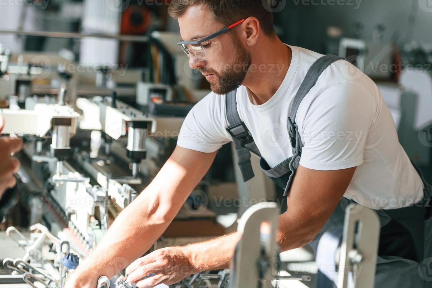 Technician is working.. Handsome, man is at the factory of creating eco boxes photo