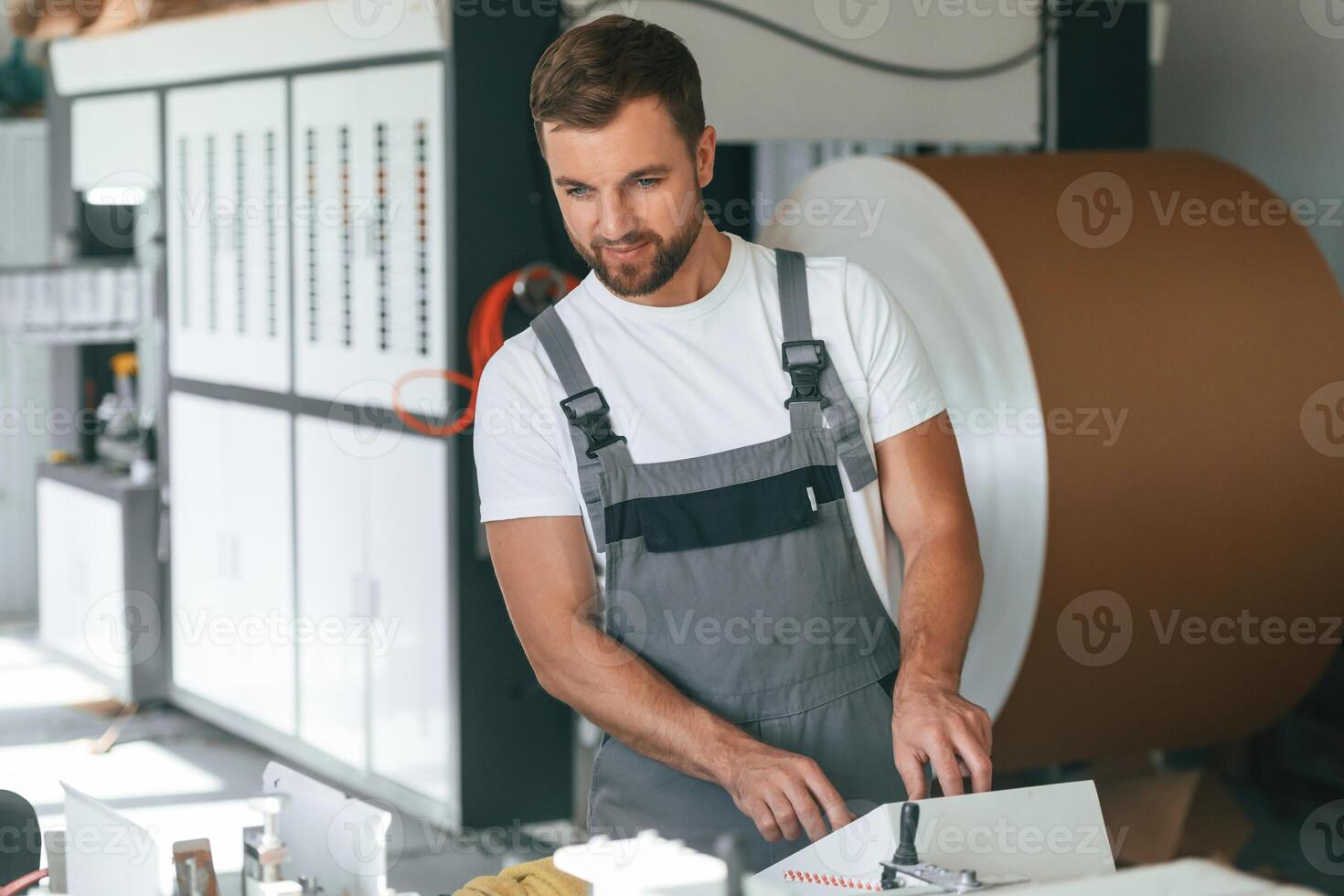 Smart engineer,. Handsome man is working at the factory of creating eco boxes photo
