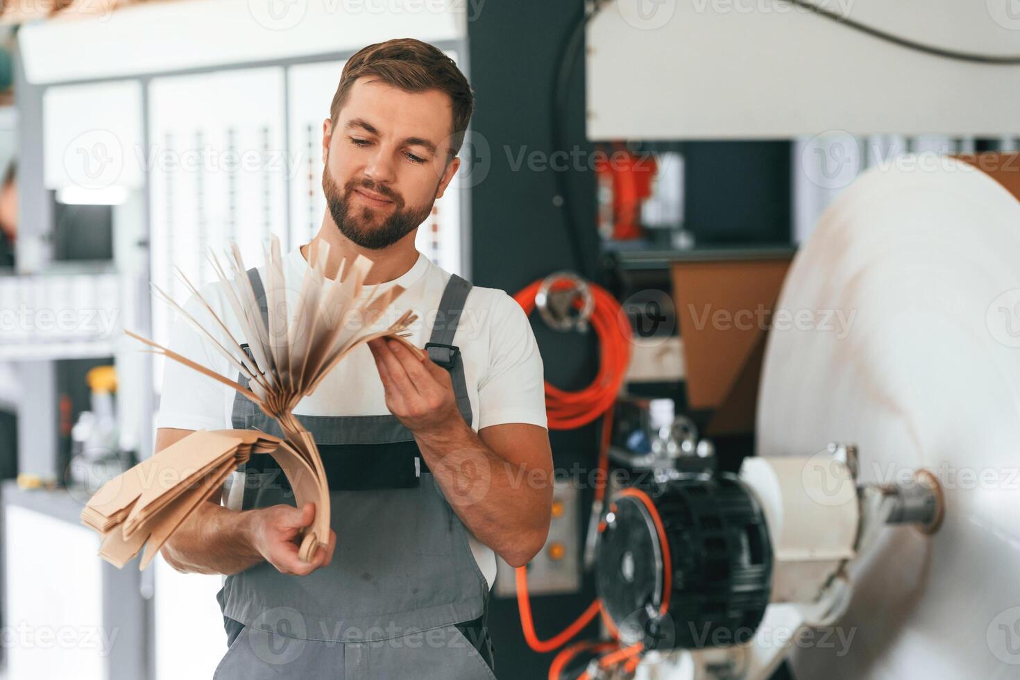 Smart, engineer. Handsome man is working at the factory of creating eco boxes photo
