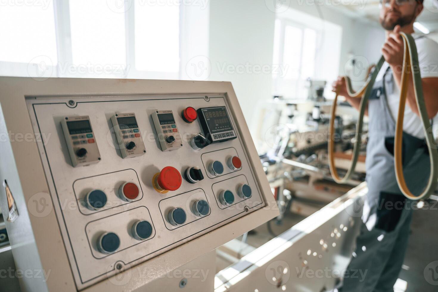 Standing by ,the machine. Handsome man is working at the factory of creating eco boxes photo