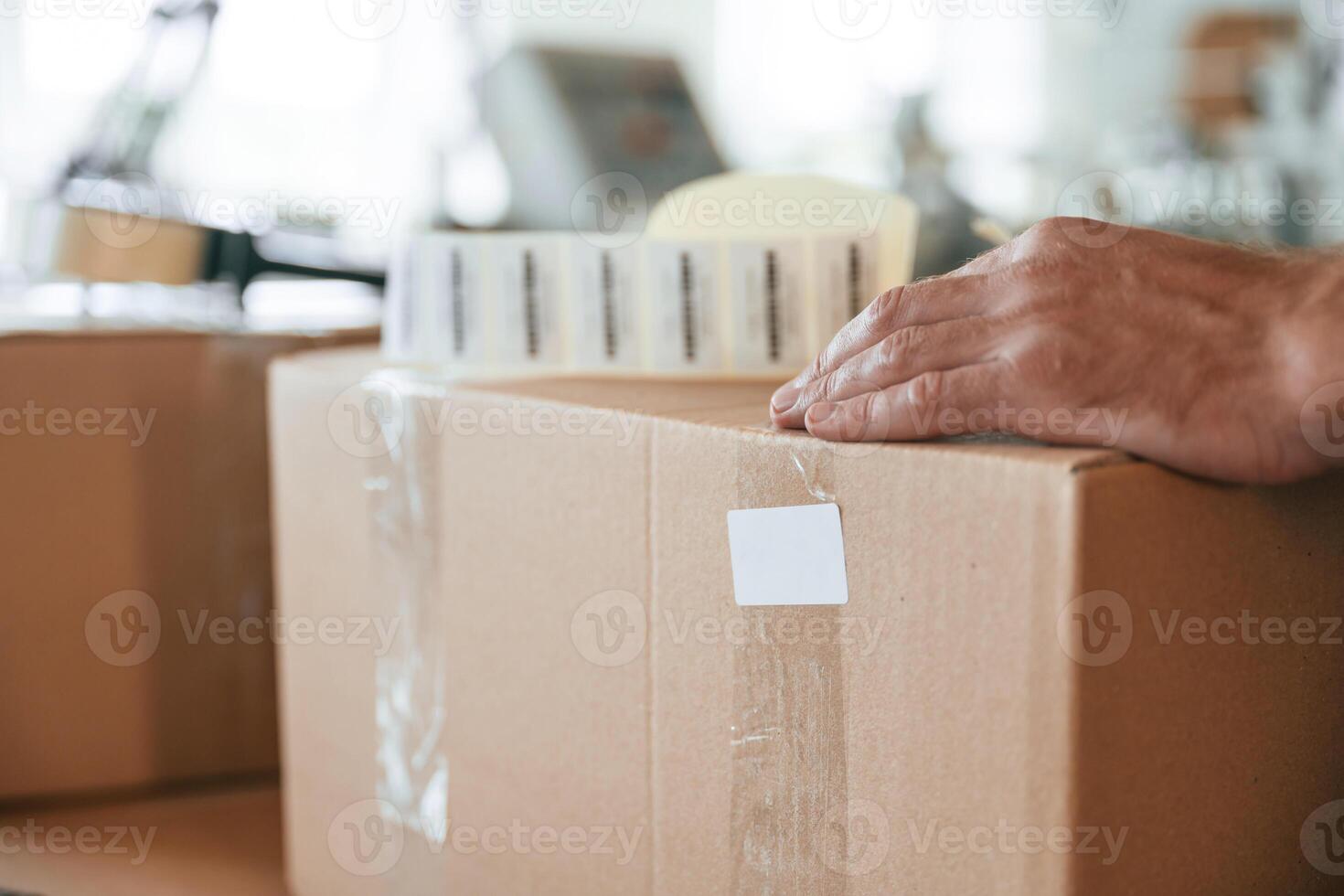 Process, of mmpackaging the product. Handsome man is working at the factory of creating eco boxes photo