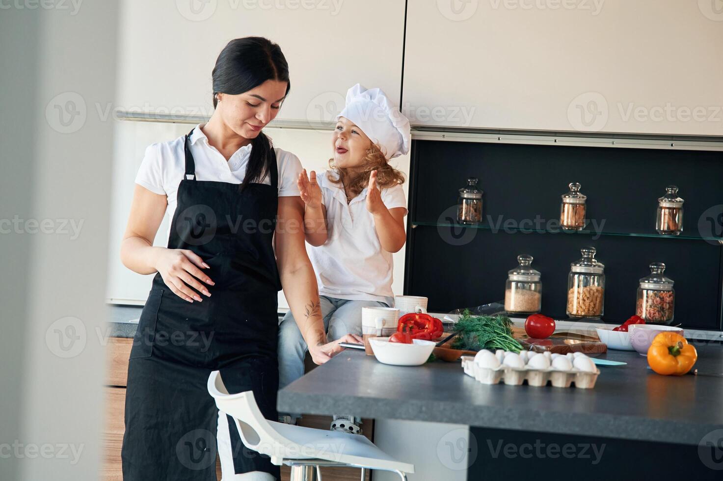 Taking a break,,. Mother with her daughter are preparing food on the kitchen photo