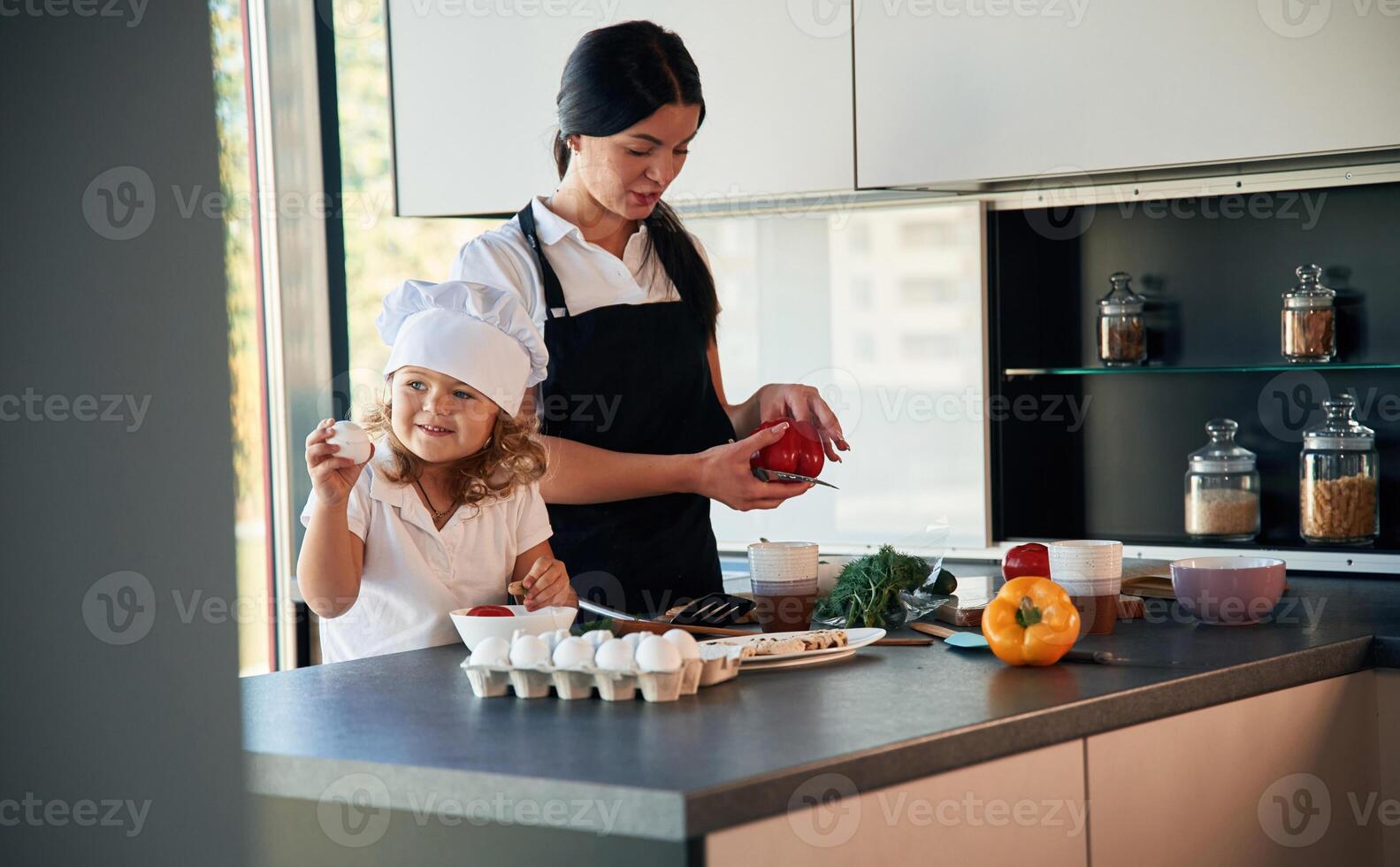 Cozy atmosphere. Mother with ,her ,daughter are preparing food on the kitchen photo