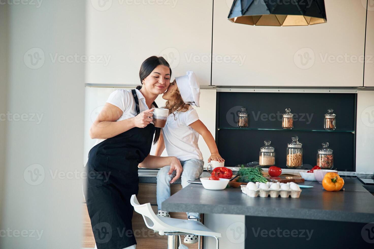 Playful mood. Mother with, her, daughter are preparing food on the kitchen photo