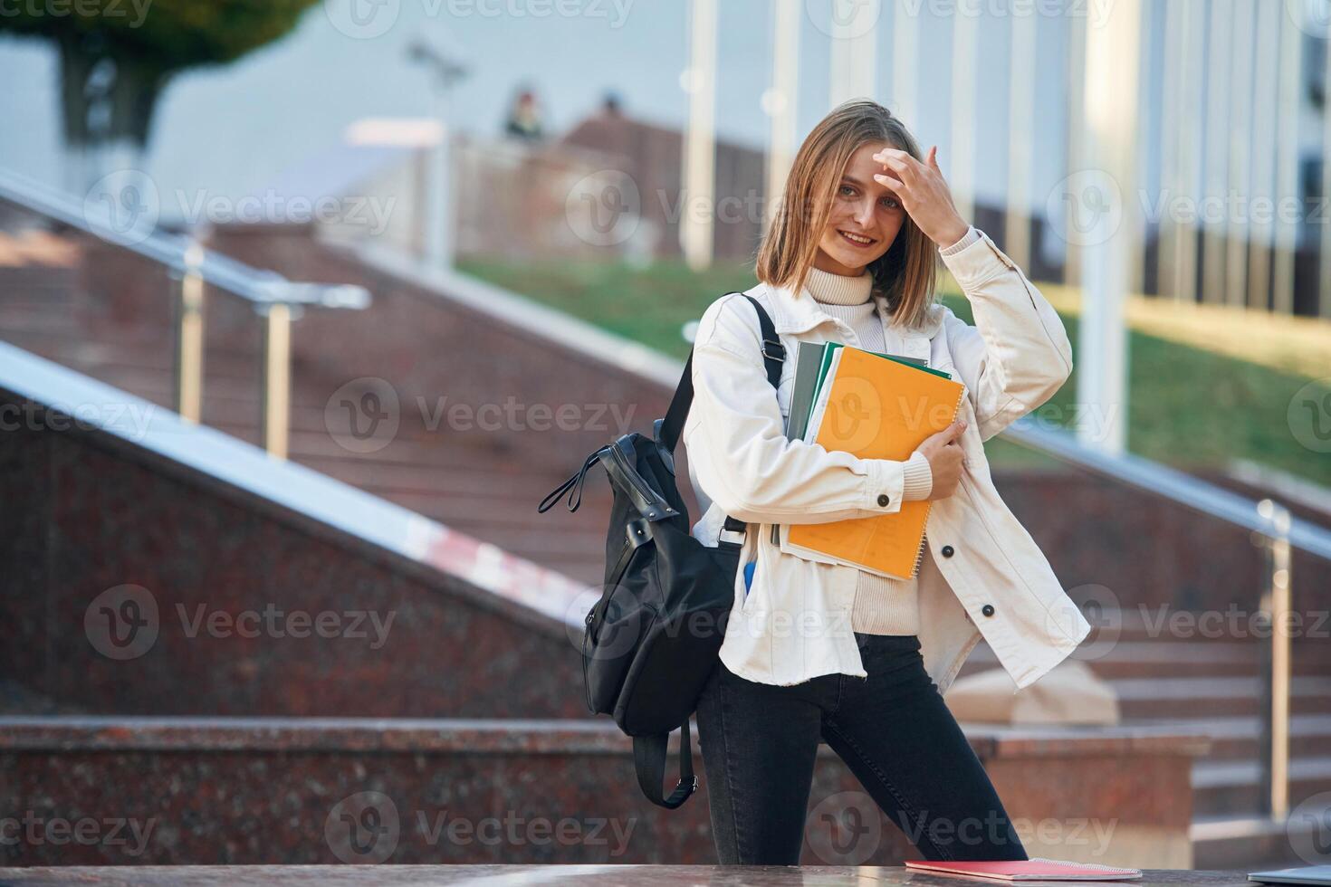 Standing and posing,. Young female student in casual clothes is outdoors photo
