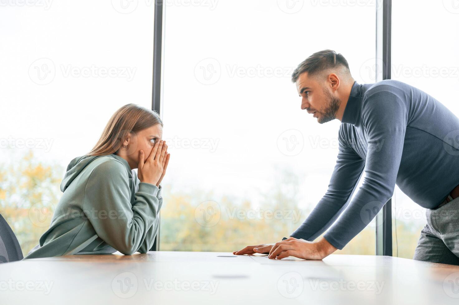 Side view, near ,big window. Man is screaming at his girlfriend, conception of quarrel photo