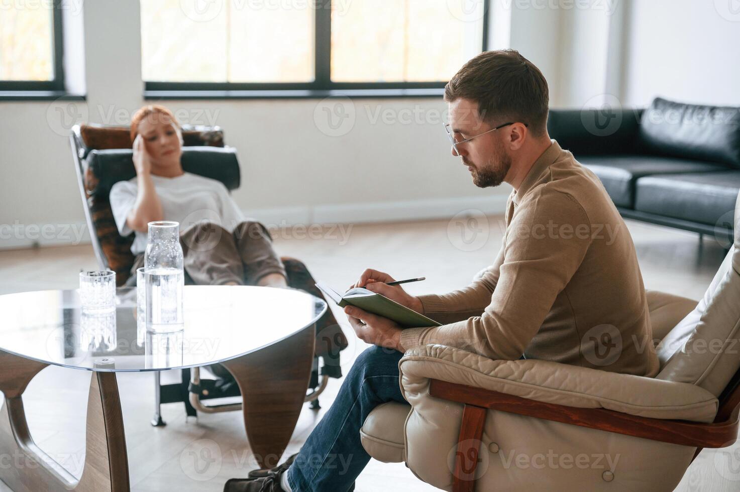 Helping the patient.. Woman is sitting, in chair at an appointment with a psychologist photo