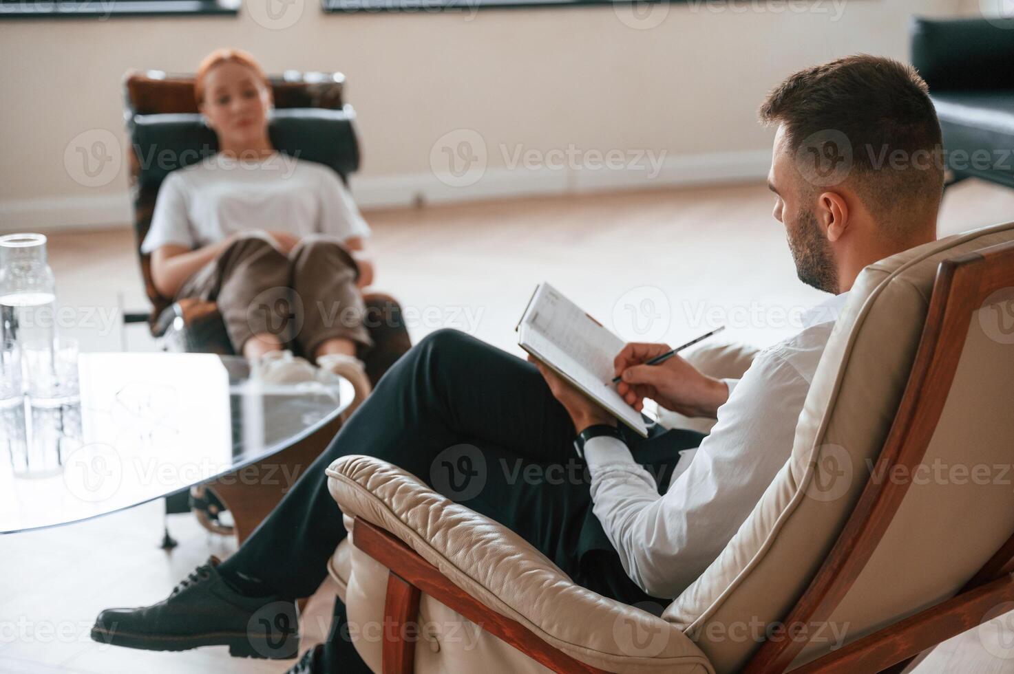 Woman is, sitting in chair at an appointment with a psychologist photo