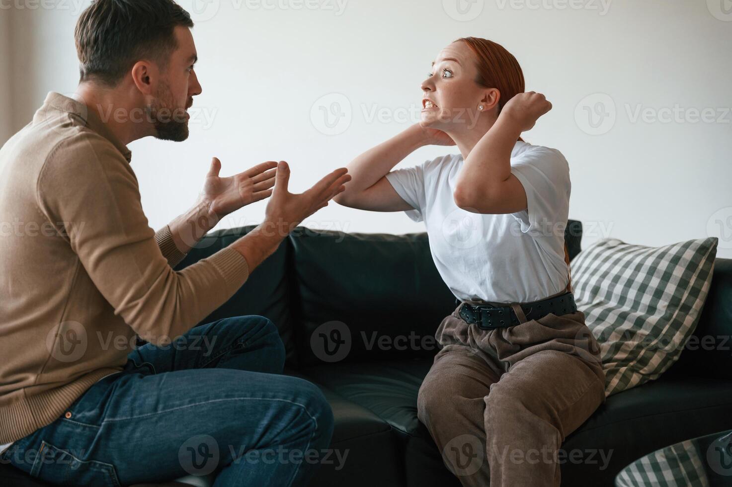 Side view of couple that are arguing... Sitting on sofa photo