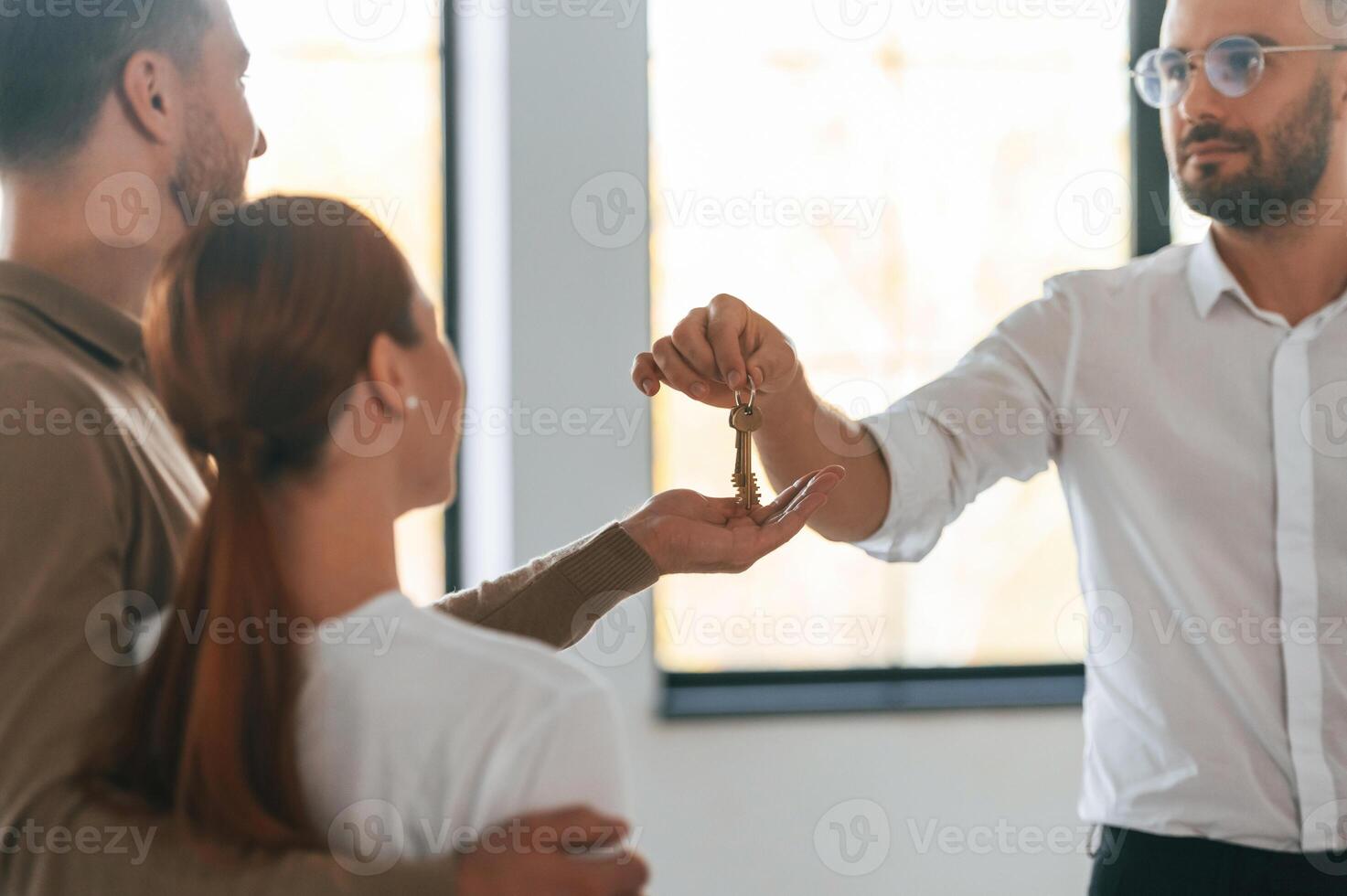 Customers bought,, the place, receiving the keys. Realtor shows an apartment to a young couple photo