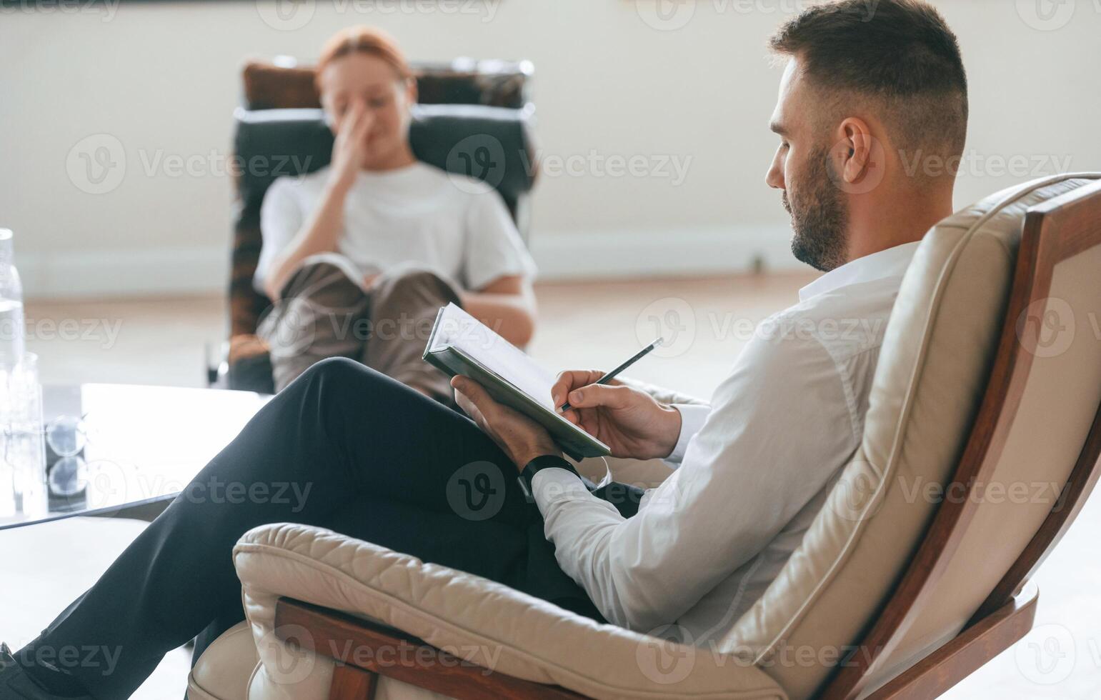 Woman, is sitting in chair at an appointment with a psychologist photo