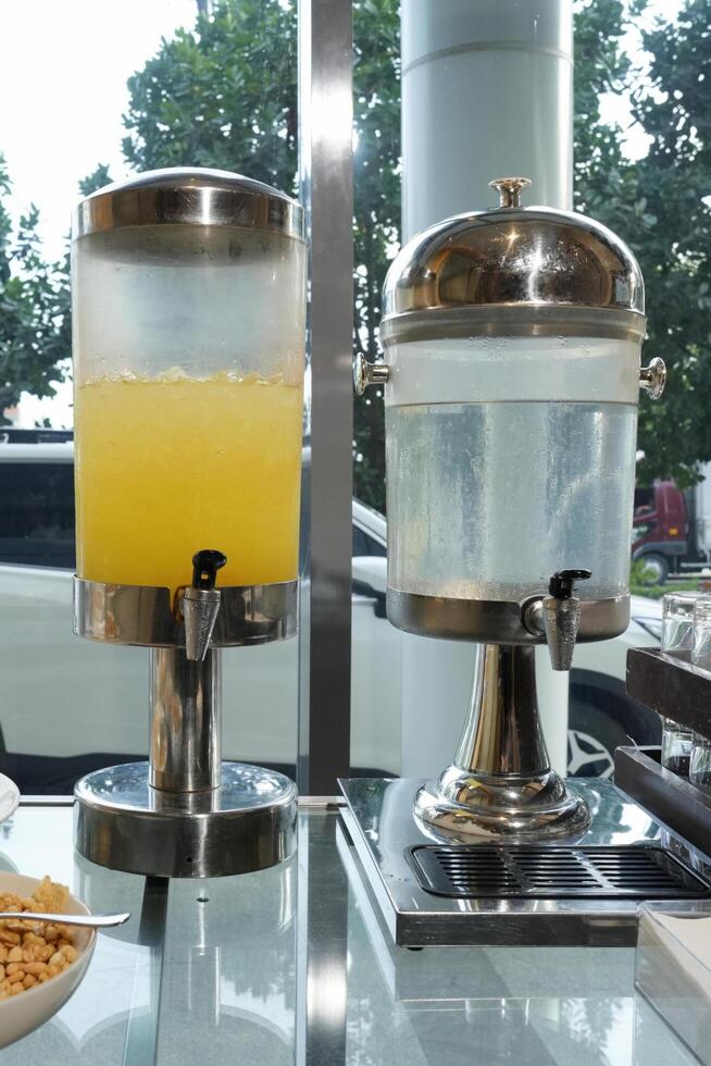 juice jugs with pineapple juice and water photo