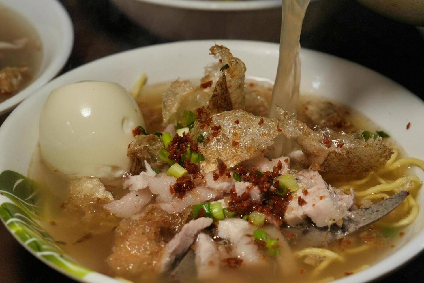a bowl of soup with meat and noodles photo