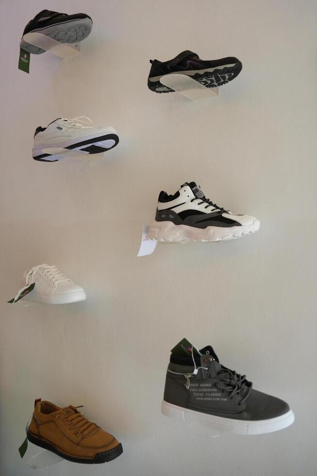 a wall with several pairs of shoes on display photo