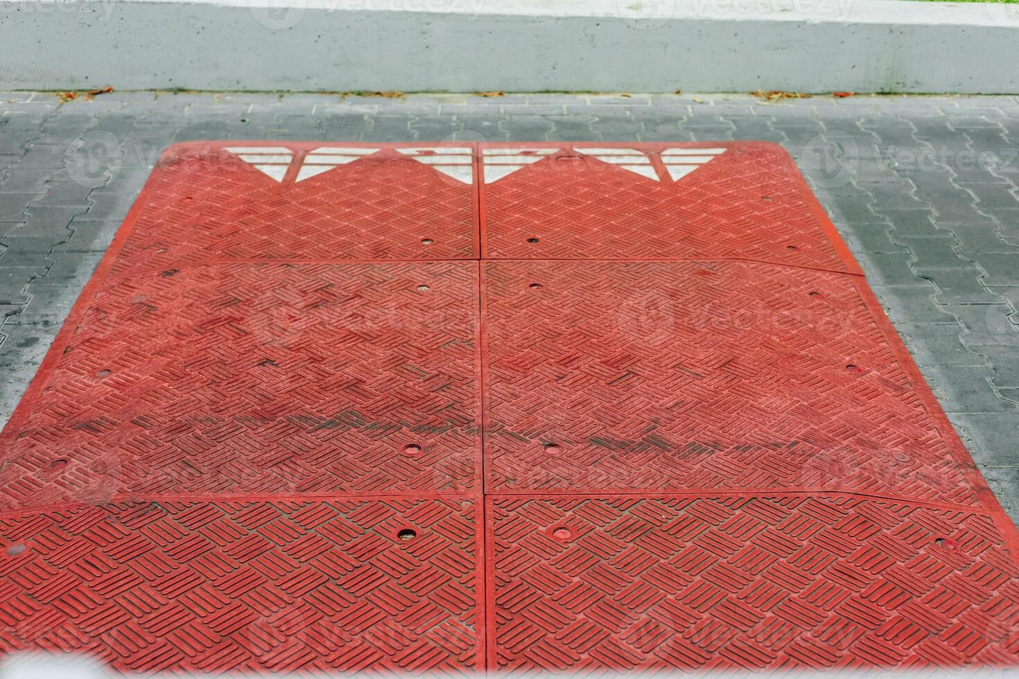 Bright red speed bump on a city street during the afternoon photo