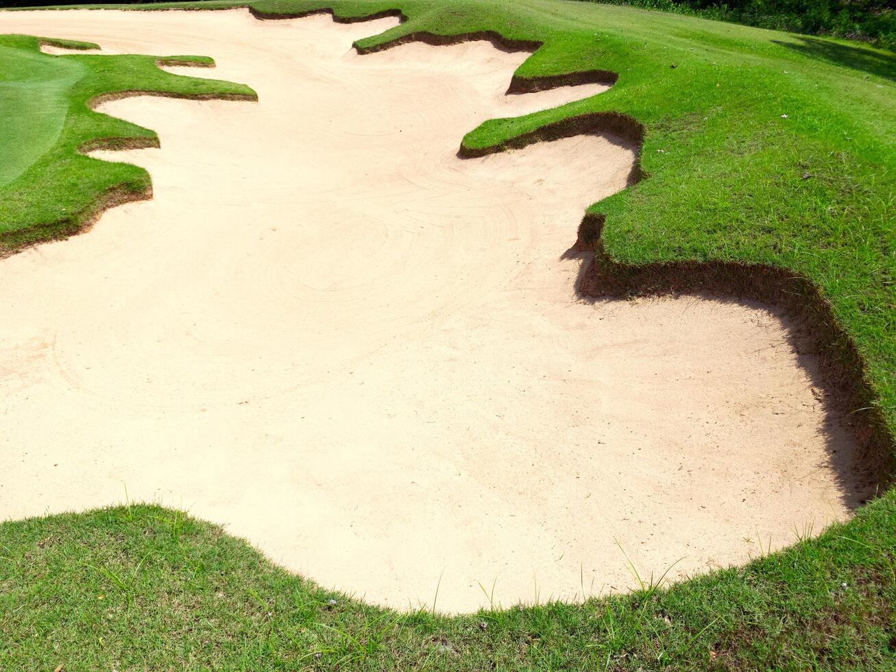 Well-maintained sand trap at a golf course, featuring even raked sand photo
