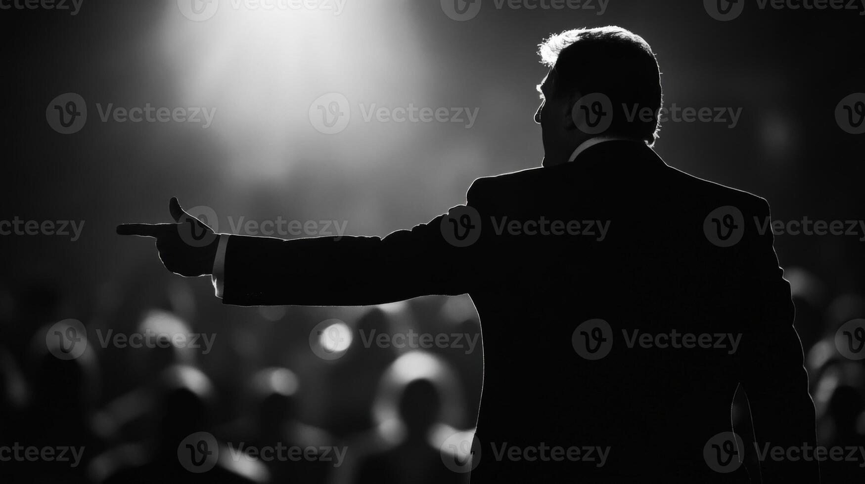 Call to Action The politician their jaw set with resolve points outward as if inviting the crowd to join in a common cause with the blurred figures of supporters caught in midchee photo