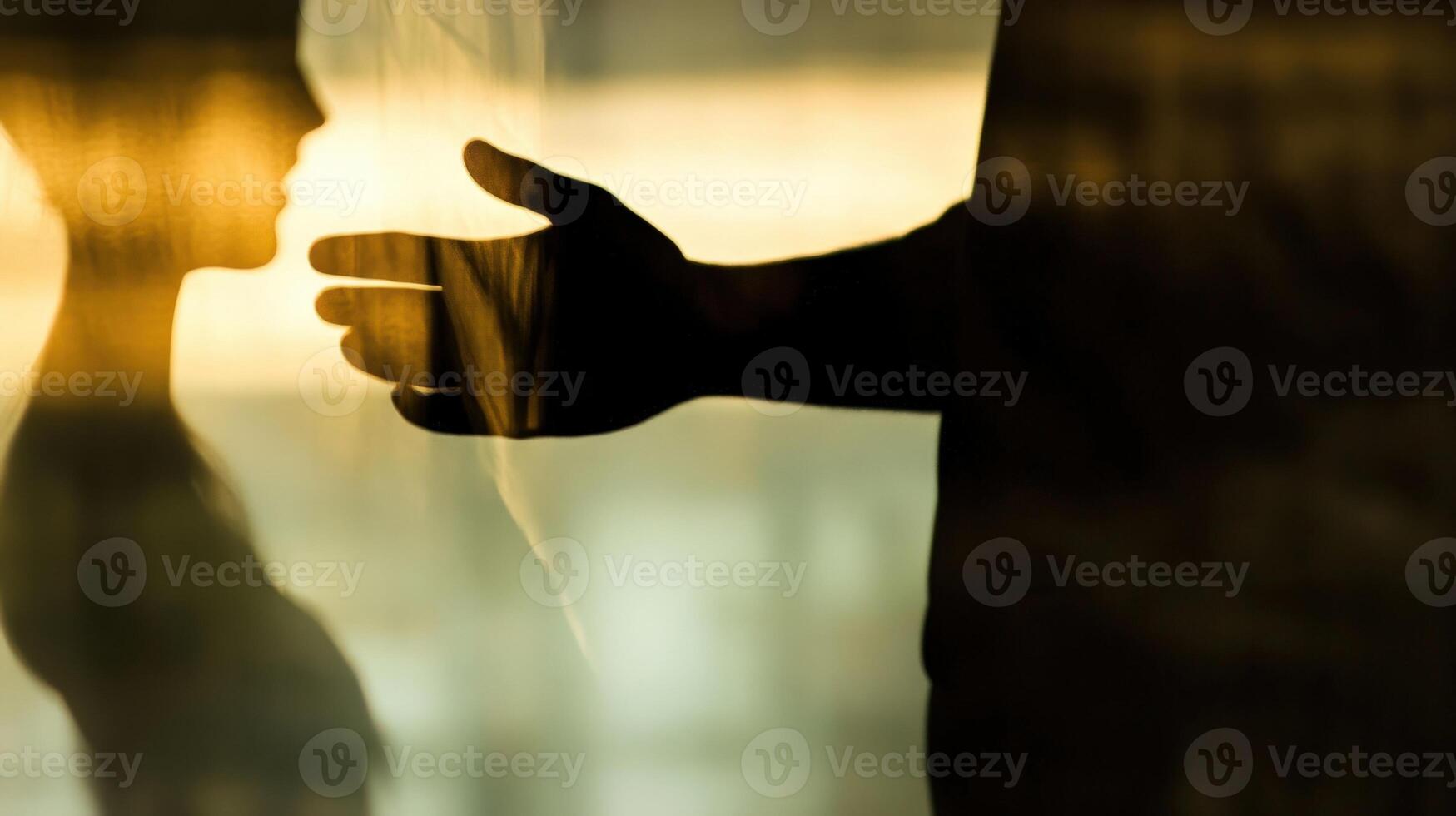 Politician reaching for voter in silhouette behind frosted glass photo