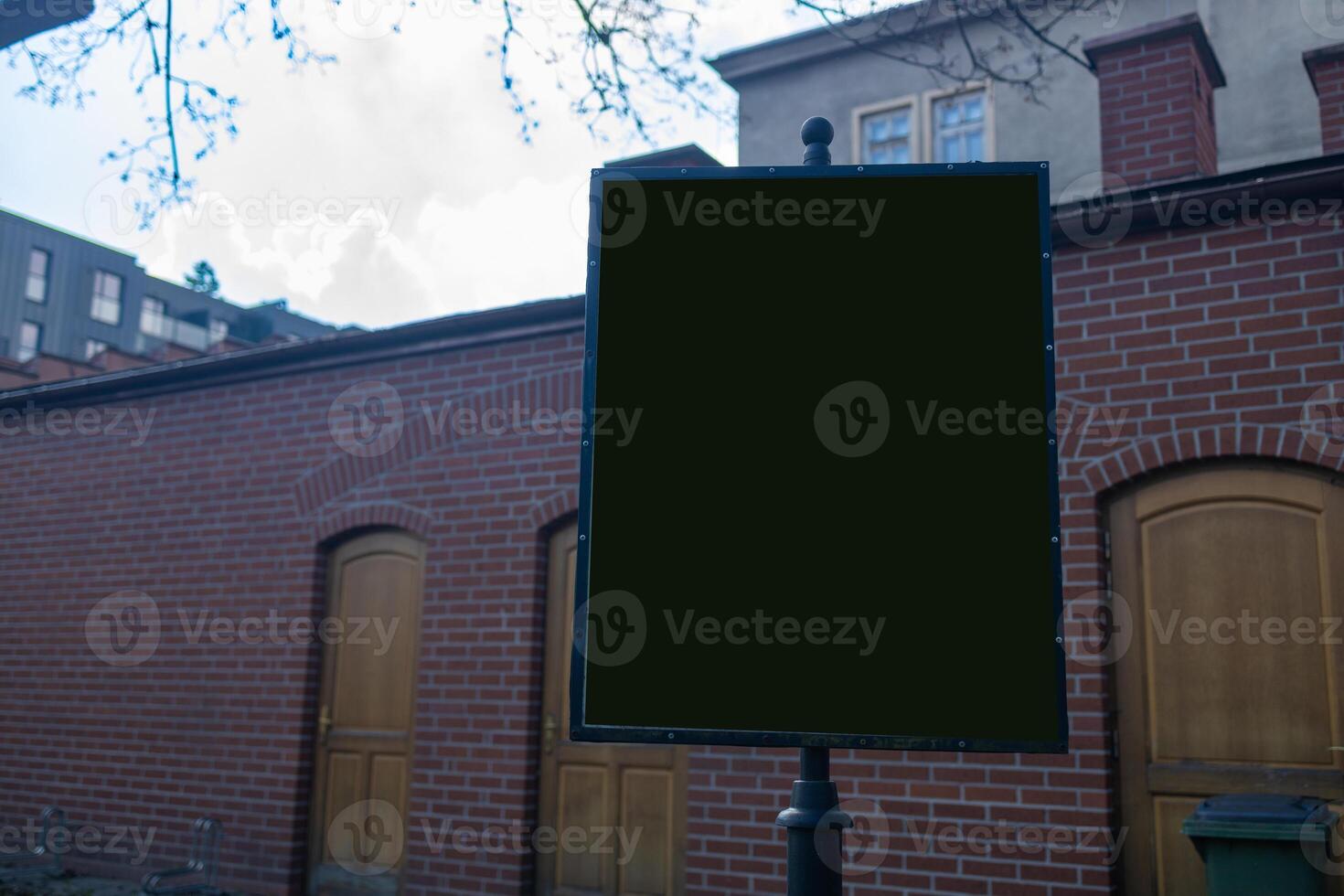 Empty sign on a street pole near a brick wall photo