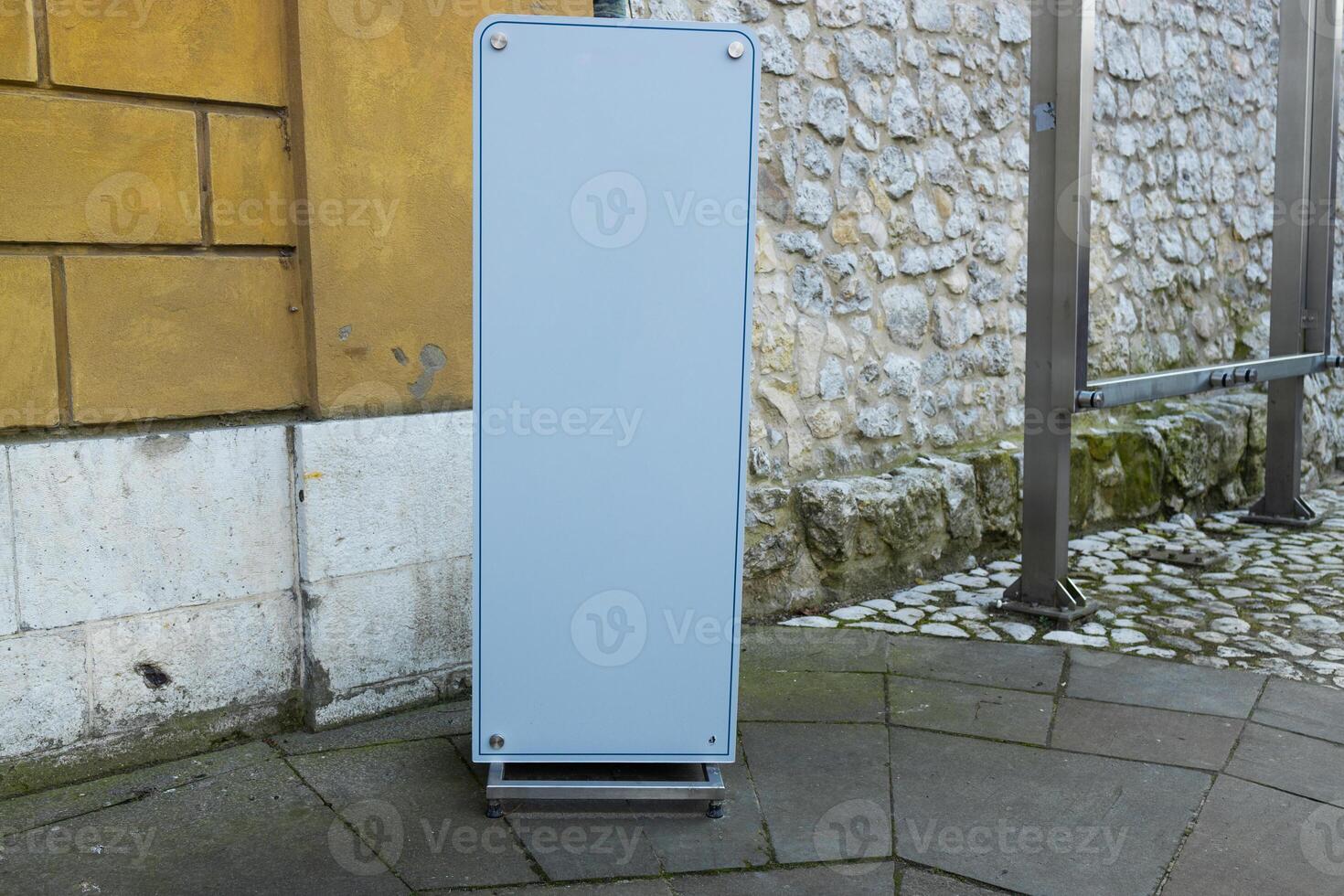 Blank Advertising Board Stand on Urban Street Corner photo
