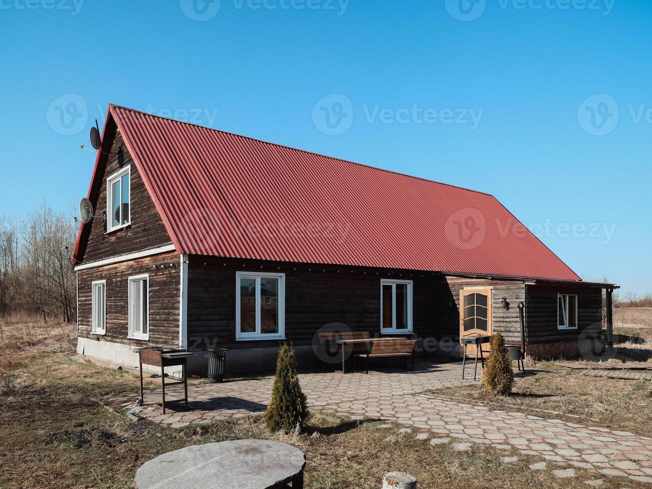 Charming Wooden House with a Bright Red Roof Surrounded by Scenic and Picturesque Nature photo