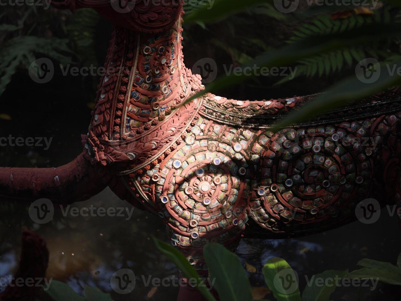 An Intricate and Artistic Sculpture Beautifully Set in Lush Greenery All Around It photo