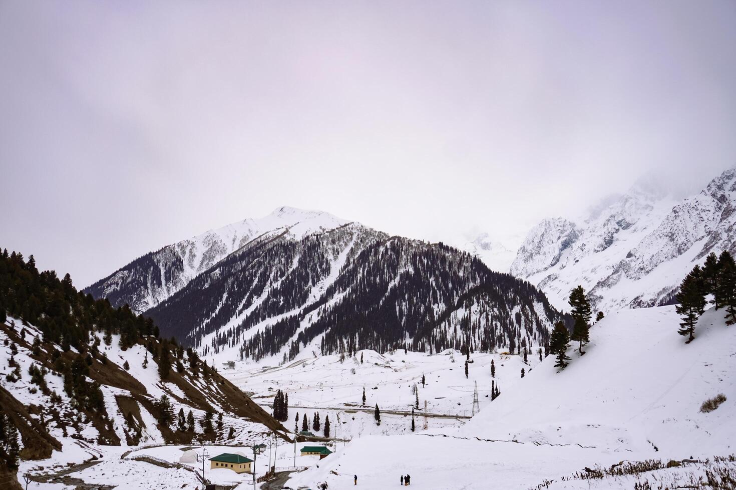 A snowy mountain valley with a road leading to it photo