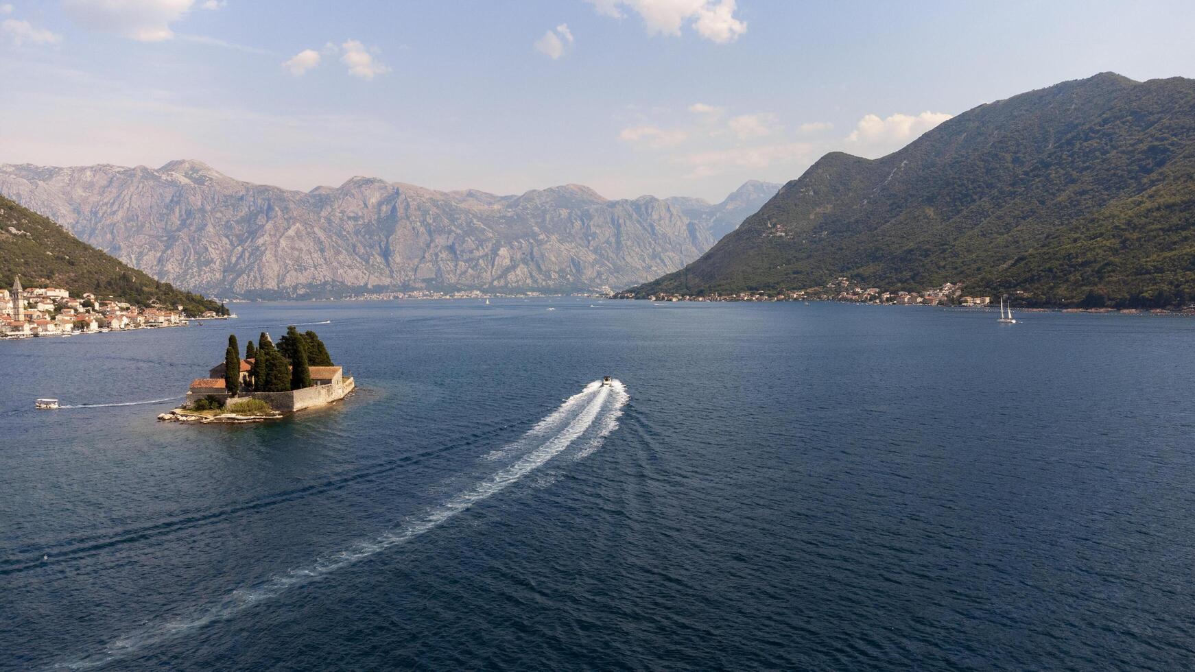 Boat in the bay of kotor near the city of Perast in the Bay of Kotor in Montenegro. Aerial view of the island travel destination in the Adriatic Sea photo