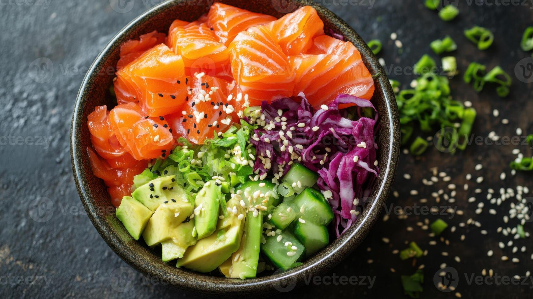Close up of salmon avocado bowl with cabbage cucumber scallions and sesame seeds on dark rustic surface healthy meal photo