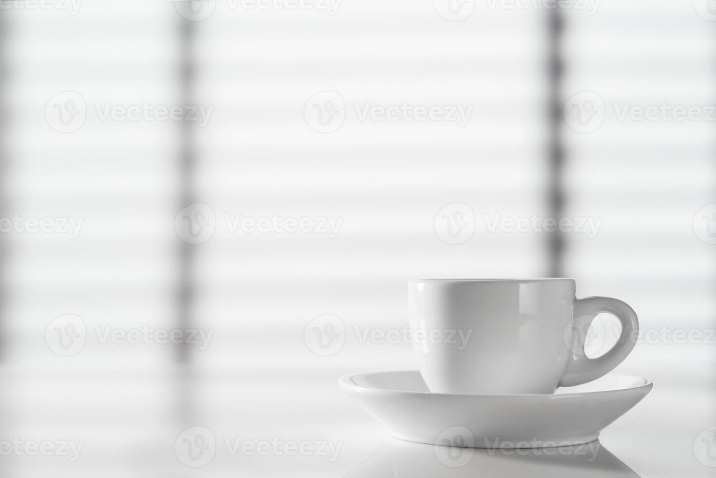 White cup of espresso on the table against the background of the window photo