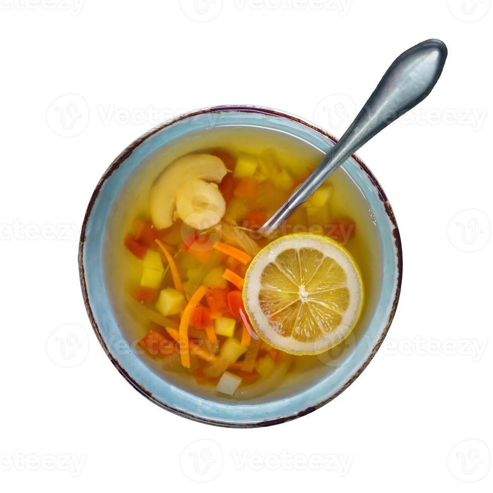 Fresh Vegetable Soup with Lemon Slice and Ginger in Pastel Bowl photo