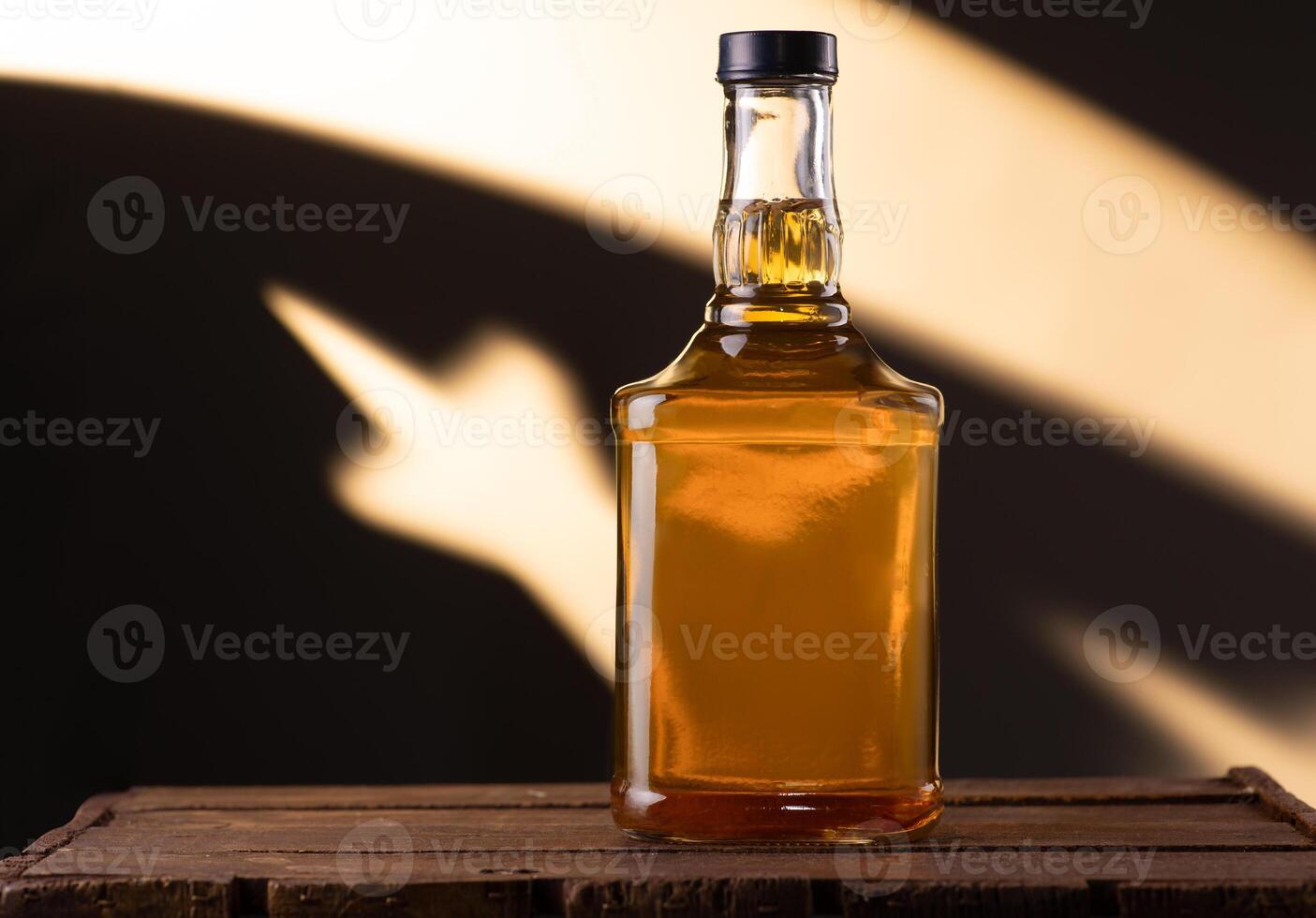 A bottle of cognac on a wooden surface photo