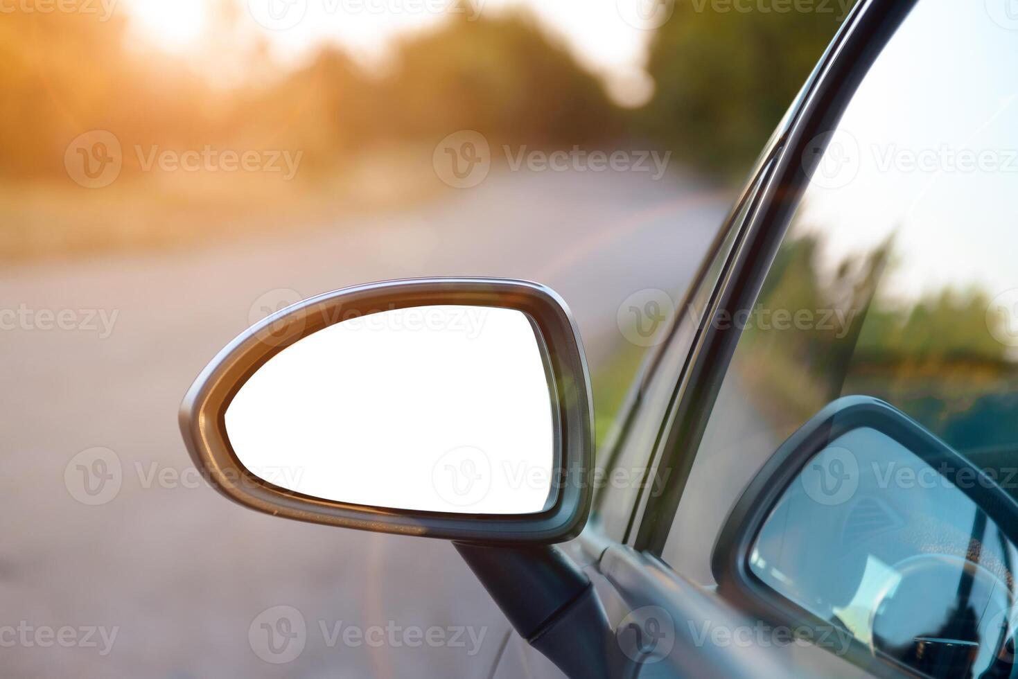 A car side view mirror is seen in the road photo