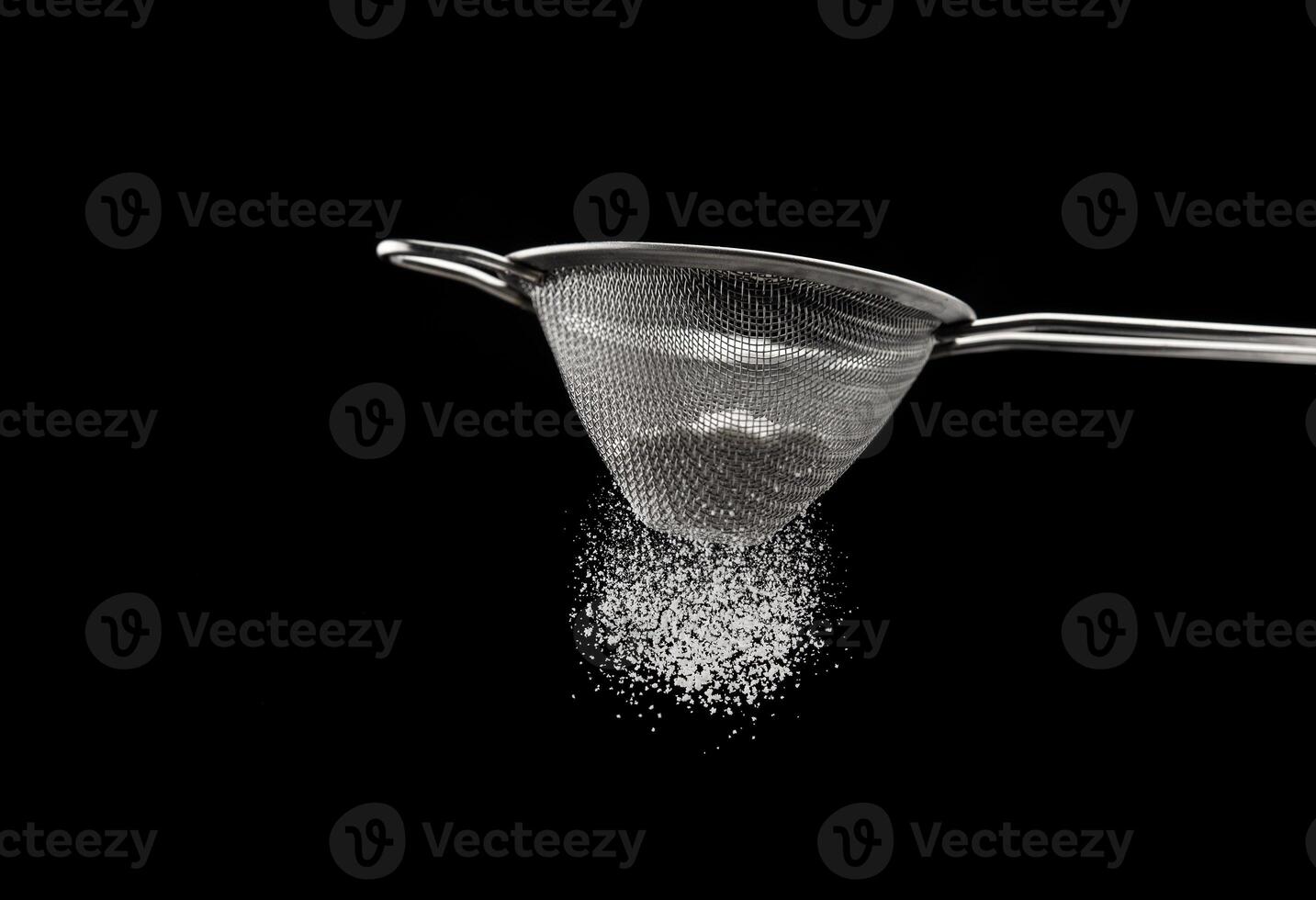 Sifting flour through a sieve photo