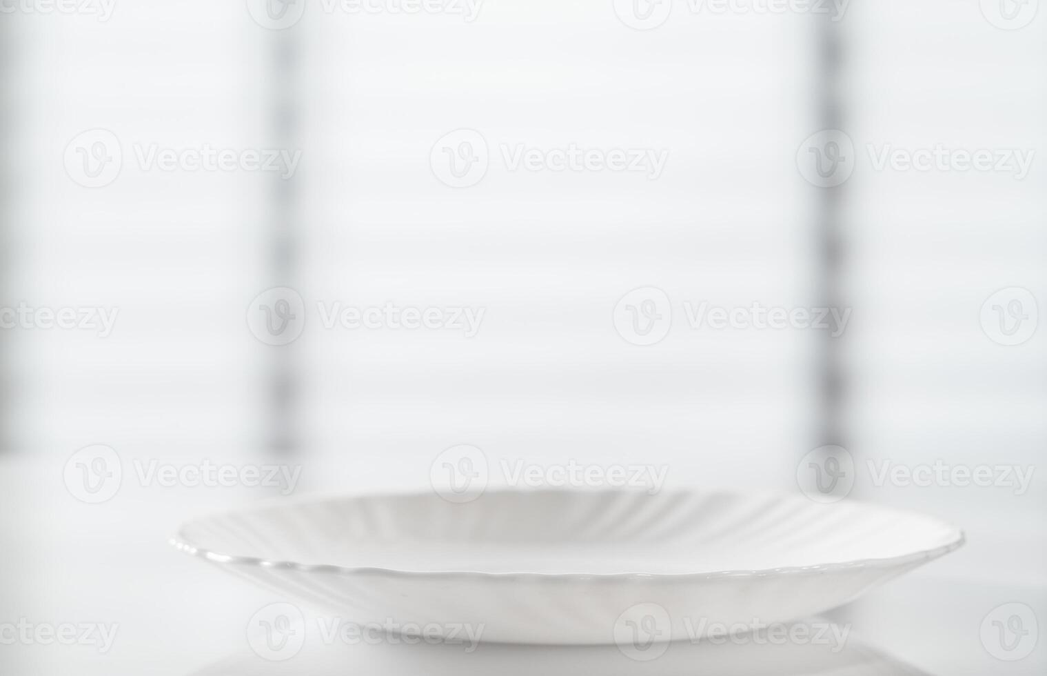 Empty white plate on table with blurred background photo