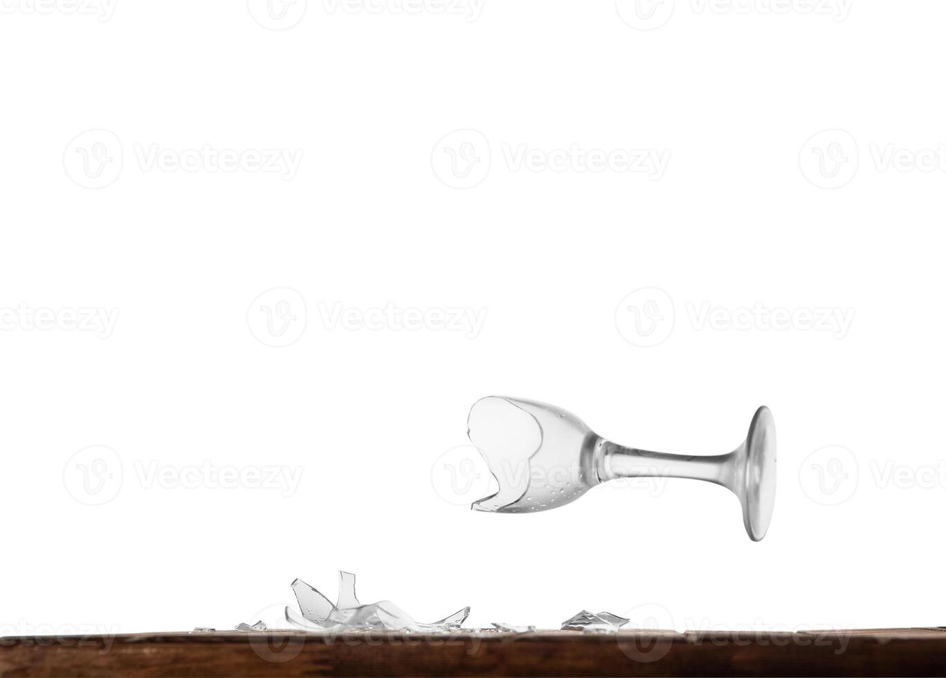 Broken wine glass on a table behind an isolated background photo